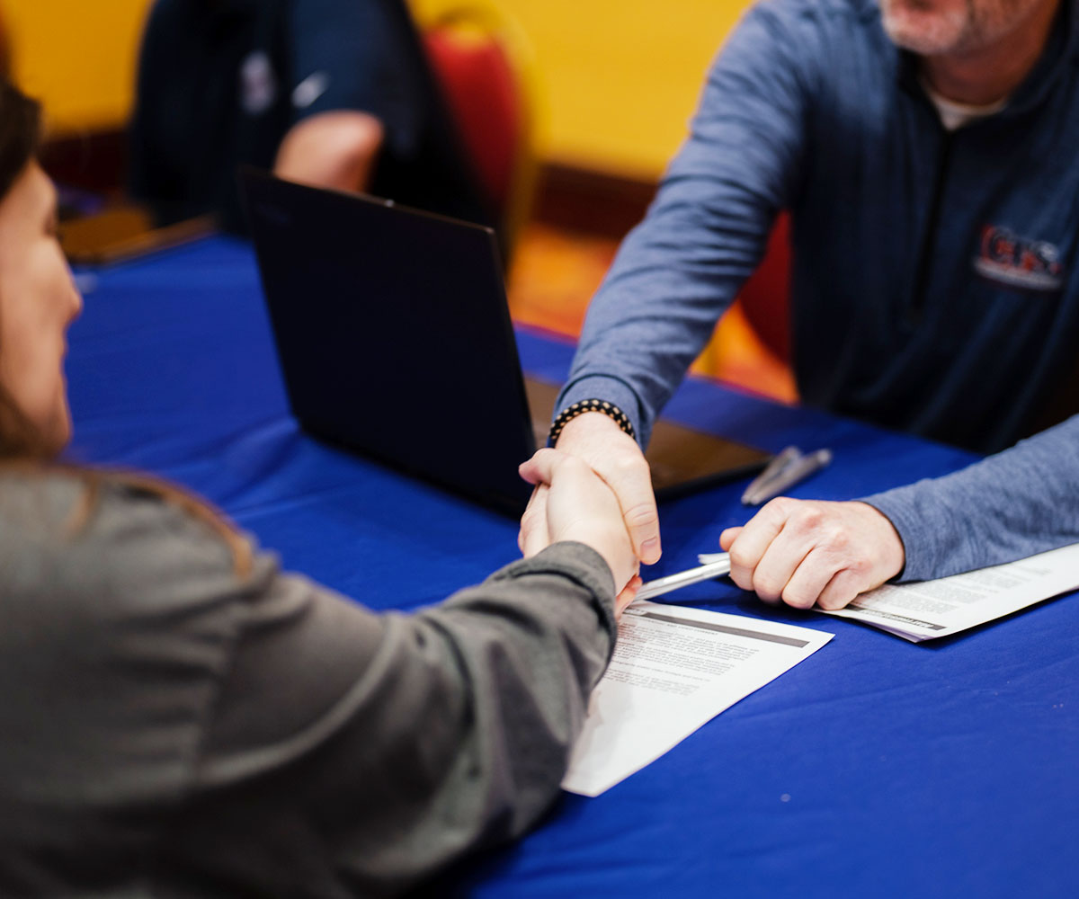 Two People Shaking Hands at Booth